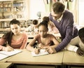 Teacher helping African-American pupil in classroom Royalty Free Stock Photo