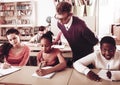 Teacher helping African-American pupil in classroom Royalty Free Stock Photo