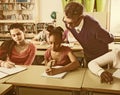 Teacher helping African-American pupil in classroom Royalty Free Stock Photo