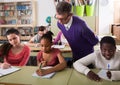 Teacher helping African-American pupil in classroom Royalty Free Stock Photo