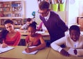 Teacher helping African-American pupil in classroom Royalty Free Stock Photo