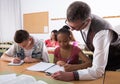 Teacher helping African-American schoolgirl in classroom Royalty Free Stock Photo