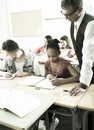 Teacher helping African-American schoolgirl in classroom Royalty Free Stock Photo