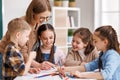 Teacher helping children with schoolwork at school