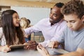 Teacher helping elementary school kids using tablet computer Royalty Free Stock Photo