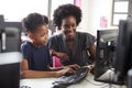 Teacher Helping Female High School Student Working at Screen In Computer Class Royalty Free Stock Photo