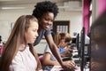Teacher Helping Female Pupil Line Of High School Students Working at Screens In Computer Class Royalty Free Stock Photo