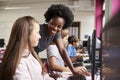 Teacher Helping Female Pupil Line Of High School Students Working at Screens In Computer Class Royalty Free Stock Photo