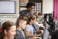 Teacher Helping Female Pupil Line Of High School Students Working at Screens In Computer Class Royalty Free Stock Photo
