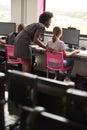 Teacher Helping Female Pupil Line Of High School Students Working at Screens In Computer Class Royalty Free Stock Photo