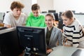 Teacher helping girl and boys to solve computer problem Royalty Free Stock Photo