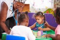 Teacher helping kids in a preschool class, close up