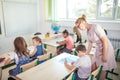 Teacher helping kids with their homework in classroom at school Royalty Free Stock Photo