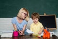 Teacher helping kids with their homework in classroom at school. Preschooler. Home schooling or private school