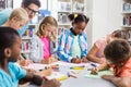 Teacher helping kids with their homework in library Royalty Free Stock Photo