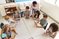 Teacher helping kids using tablets in lesson, elevated view Royalty Free Stock Photo