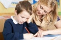 Teacher Helping Male Elementary School Pupil With Problem Royalty Free Stock Photo