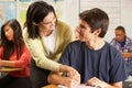 Teacher Helping Male Pupil Studying At Desk In Cla Royalty Free Stock Photo