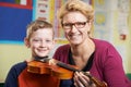 Teacher Helping Male Pupil To Play Violin In Music Lesson Royalty Free Stock Photo