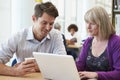 Teacher Helping Mature Student With Studies In Library Royalty Free Stock Photo