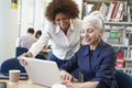Teacher Helping Mature Student With Studies In Library Royalty Free Stock Photo