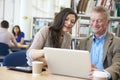 Teacher Helping Mature Student With Studies In Library Royalty Free Stock Photo