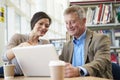 Teacher Helping Mature Student With Studies In Library Royalty Free Stock Photo