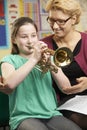 Teacher Helping Pupil To Play Trumpet In Music Lesson Royalty Free Stock Photo