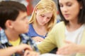 Teacher Helping Pupils Studying At Desks In Classroom Royalty Free Stock Photo