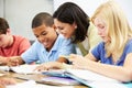 Teacher Helping Pupils Studying At Desks In Classroom Royalty Free Stock Photo