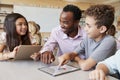 Teacher helping school kids using tablet computers in lesson Royalty Free Stock Photo