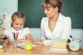 Teacher helping schoolgirl with her homework in classroom at school Royalty Free Stock Photo