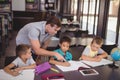 Teacher helping schoolkids with their homework in library Royalty Free Stock Photo