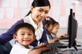 Teacher Helping Student During Computer Class