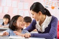 Teacher Helping Student Working In Chinese School