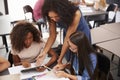 Teacher helping students with technology, high angle