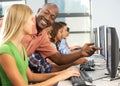 Teacher Helping Students Working At Computers In Classroom Royalty Free Stock Photo