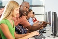 Teacher Helping Students Working At Computers In Classroom Royalty Free Stock Photo