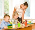 Teacher helps the schoolkids with schoolwork in classroom Royalty Free Stock Photo