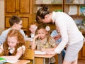 Teacher helps the schoolkids with schoolwork in classroom Royalty Free Stock Photo