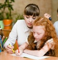 Teacher helps the student with schoolwork in school classroom Royalty Free Stock Photo
