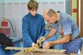 The teacher helps the teenager to construct plane model on an av