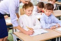 Teacher and her pupil are writing together