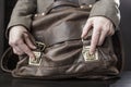 Teacher in a jacket gets a book from an old leather briefcase Royalty Free Stock Photo