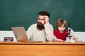 Teacher and kid. father teaching her son in classroom at school. Teacher helping young boy with lesson. Teacher helping Royalty Free Stock Photo