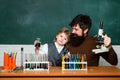 Teacher and kid. Teacher helping his teen students with chemistry or biology on education class. Teacher helping pupils Royalty Free Stock Photo