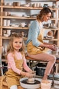 teacher and kid making ceramic pots on pottery wheels Royalty Free Stock Photo