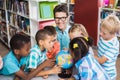 Teacher and kids discussing globe Royalty Free Stock Photo