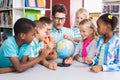 Teacher and kids discussing globe Royalty Free Stock Photo