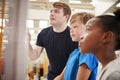 Teacher and kids looking at a science exhibit, close up